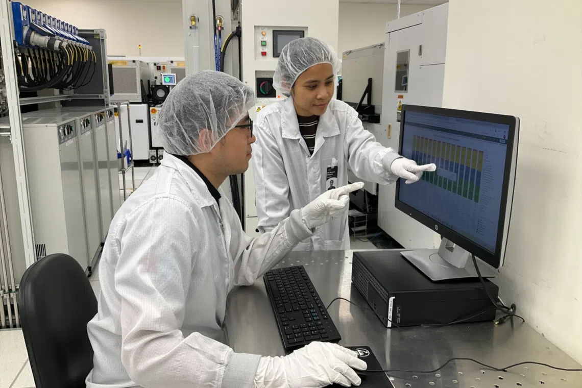 siti hanisah mustafah equipment technologist at micron technology, one of singapore’s best employers, pictured with her colleague at micron diagnosing machine faults and troubleshooting to keep production lines running smoothly