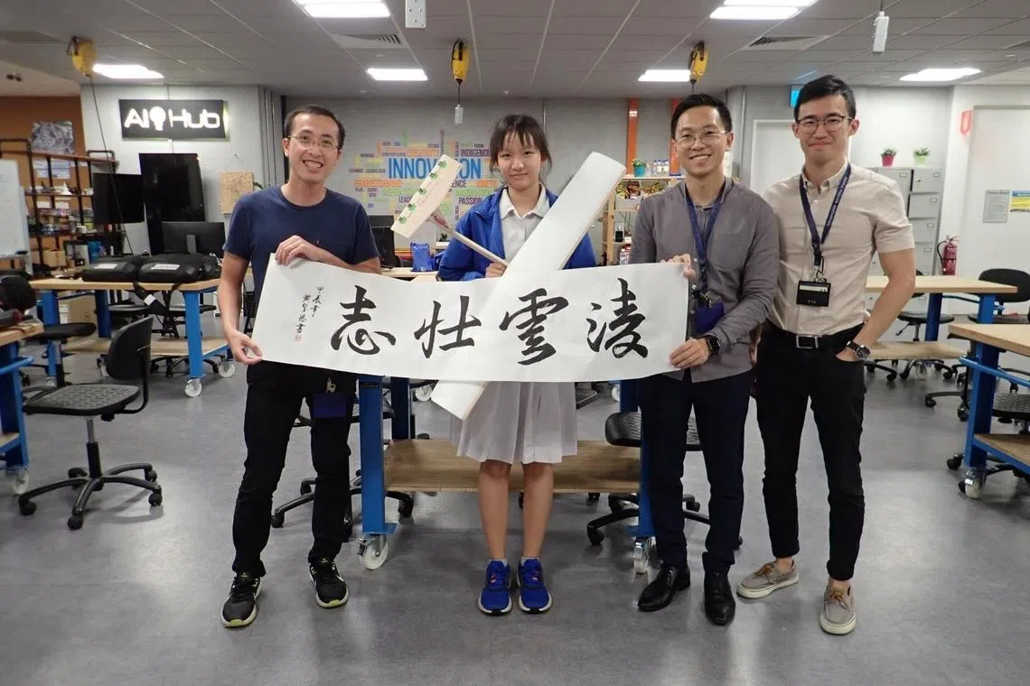 dso senior aerodynamics engineer jonathan lim (second from right) and his colleagues receiving a calligraphy note of thanks from a student at dso’s world of science workshop in 2024