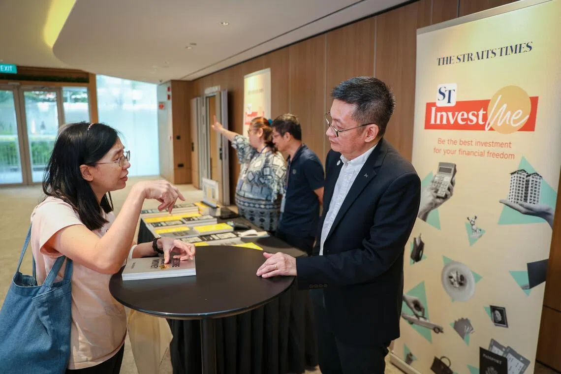 Mr Tan Ooi Boon (right), Invest editor at The Straits Times, talks with an audience member after signing her copy of his book Retire With More Money.