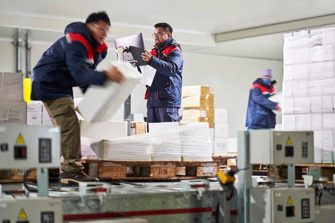 Staff pick and pack goods at the staging area before dispatch at Jurong Cold Store.