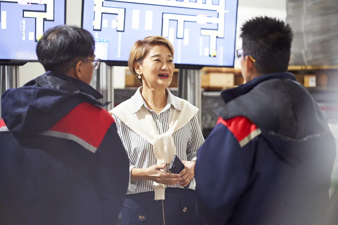 Belinda Lee discusses inventory movements with her team against a live view of Jurong Cold Store’s automated warehouse tracking system.