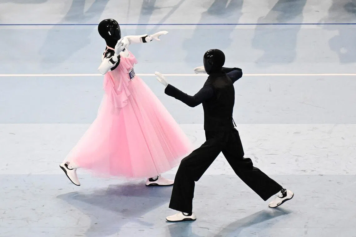 A humanoid robot pair performs in a dance event in Beijing on Aug 25.