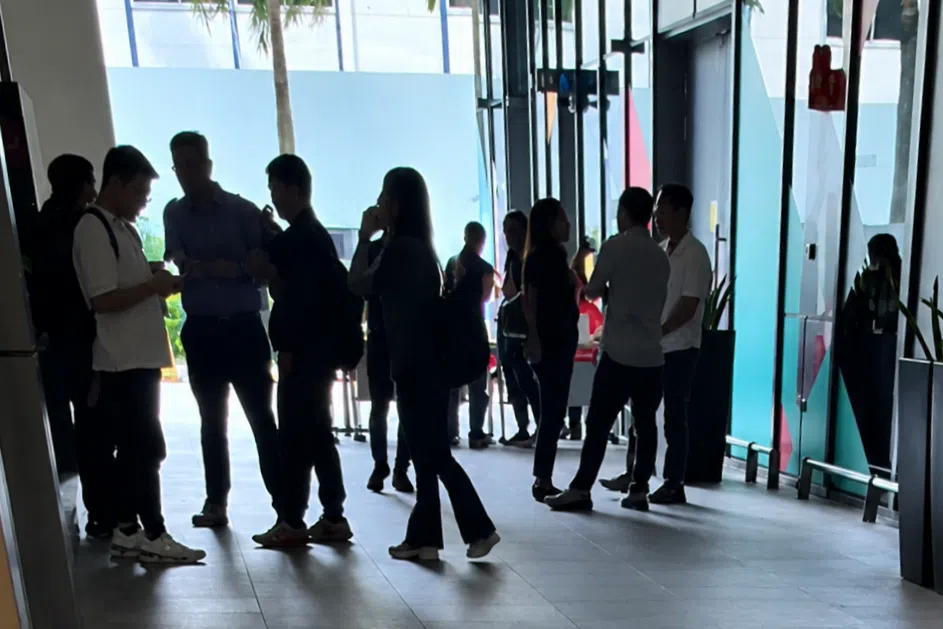Some attendees speaking with NTUC staff outside the event venue.