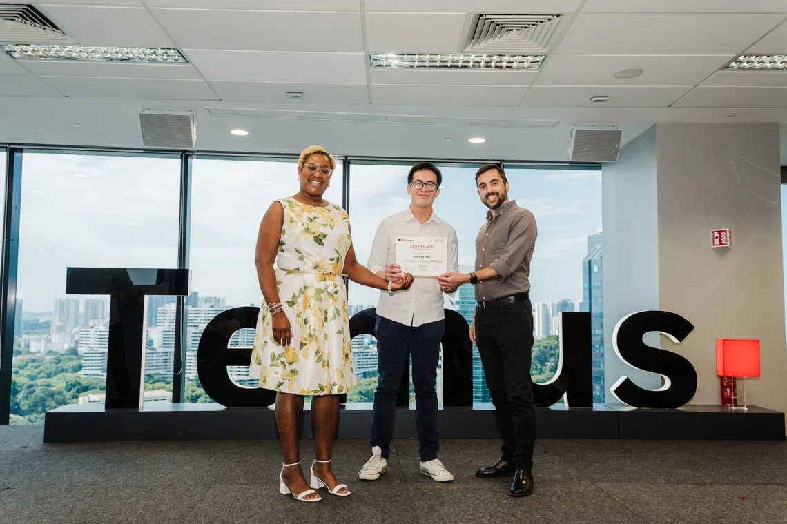 soh wen ming, centre, receiving his certificate after completing temus’ four-month step it up career conversion programme in singapore